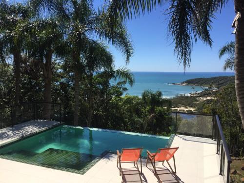 普腊亚罗萨玫瑰花蕾旅馆的一个带椅子的游泳池,享有海景