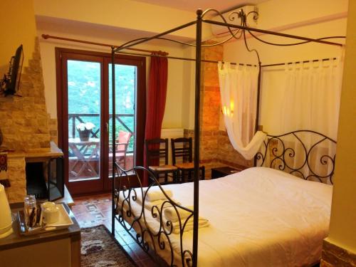 Makrirrákhi阿斯特洛米亚酒店的一间卧室设有一张天蓬床和一个阳台