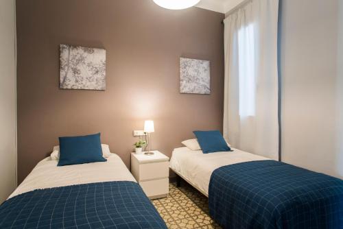巴塞罗那巴塞罗那旅客酒店的两张睡床彼此相邻,位于一个房间里