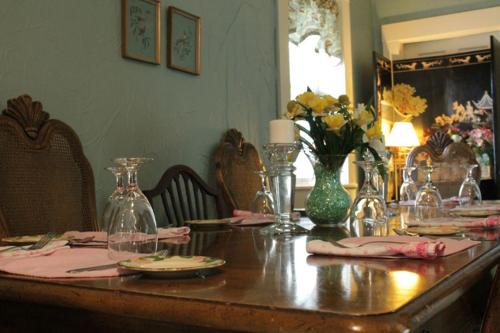 巴兹敦Jailer's Inn的一张木桌,上面有盘子和花瓶