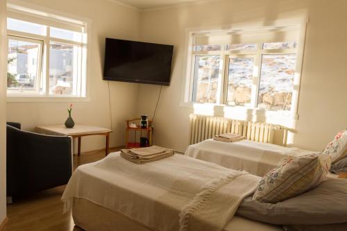 侯尔马维克Finna Hótel的客房设有两张床和一台平面电视。