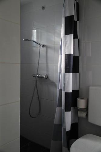 赞德沃特多朋博格经济客房住宿加早餐旅馆的浴室设有黑色和白色的淋浴帘。