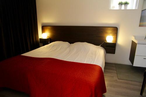 赞德沃特多朋博格经济客房住宿加早餐旅馆的卧室配有红色和白色的床及两盏灯