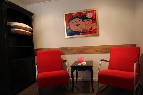 赞德沃特多朋博格经济客房住宿加早餐旅馆的两个红色的椅子和一张桌子