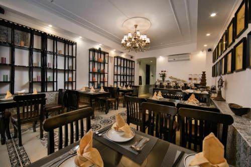 河内Hanoi Center Silk Premium Hotel & Spa & Travel的一间带桌椅和吊灯的餐厅