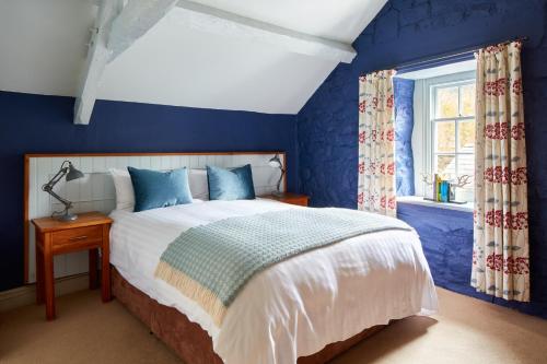 多尔盖罗Y Meirionnydd Townhouse的蓝色的卧室设有床和窗户