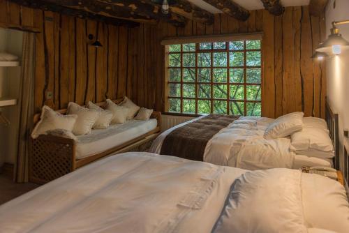富塔莱乌富Hotel El Barranco的一间卧室设有两张床和窗户。