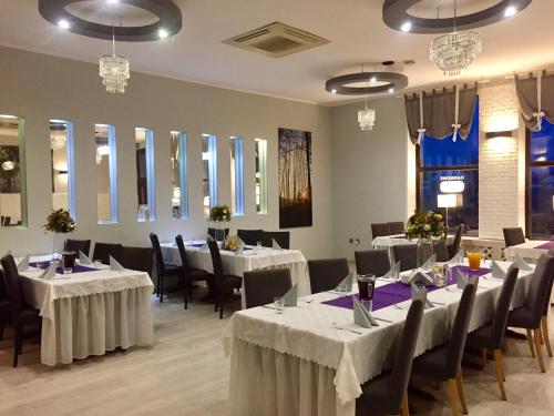 图霍拉Hotel Pod Jeleniem的用餐室配有桌椅和白色床单