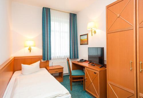 瓦伦瓦伦城市酒店的配有一张床和一张书桌的酒店客房