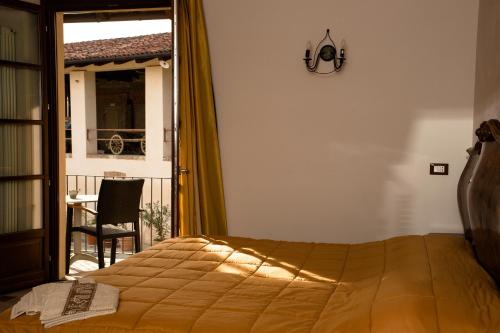 阿尔巴La Madonnina Agriturismo Dorè的一间卧室配有一张床、一张桌子和一个窗户。