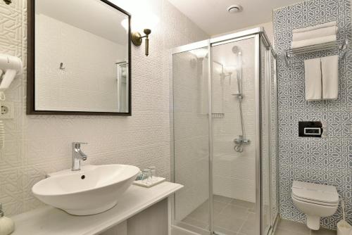 伊斯坦布尔伊斯坦布尔利夫酒店的一间带水槽和玻璃淋浴的浴室