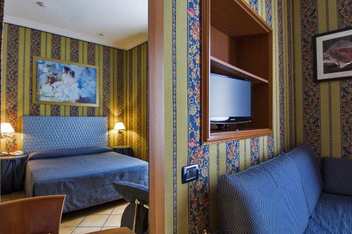 罗马里瑞科酒店的酒店客房,配有床和电视