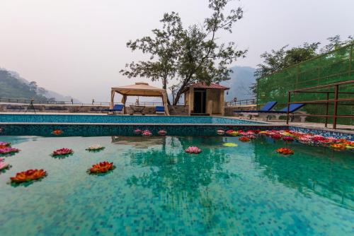 瑞诗凯诗Veda5 Ayurveda & Yoga Retreat的一座在水中种满鲜花的大型游泳池