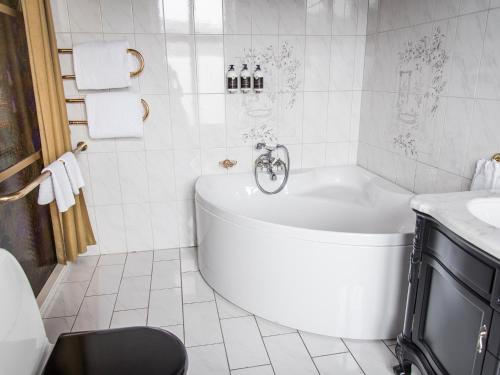 哥德堡埃格斯酒店的白色的浴室设有浴缸和水槽。