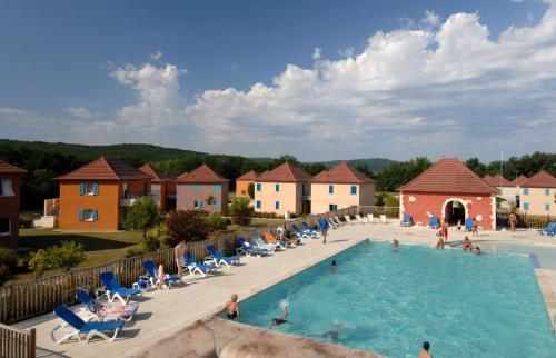 普赖萨克Terres de France - Domaine de Claire Rive的度假村的游泳池,人们坐在椅子上