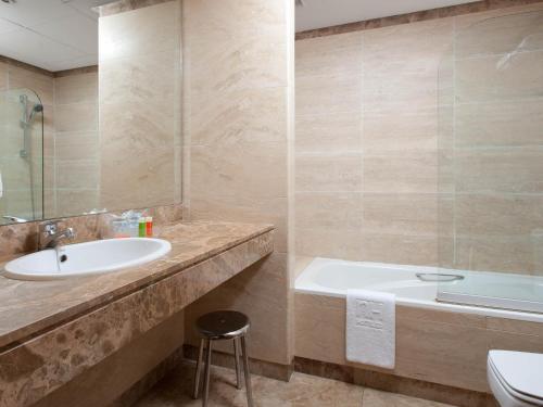 马德里Apartamentos TH La Florida的一间带水槽、浴缸和卫生间的浴室
