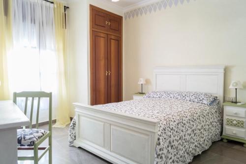 科尔多瓦Casa Ruano的白色卧室配有床和椅子