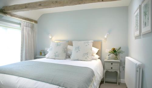 BartlowThe Three Hills的一间卧室配有带白色床单和枕头的床。