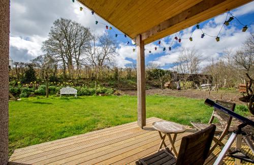 巴拉Ty'r Afon - River Cottage的庭院内带桌椅的木制甲板
