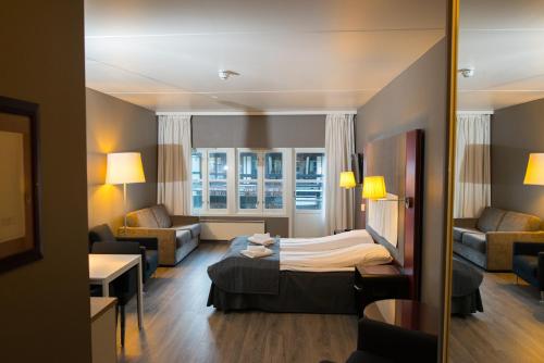 奥普达尔Oppdal Gjestetun Hotell的酒店客房设有床和客厅。