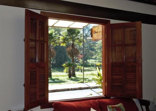 阿拉沙Chalé do Lago的享有棕榈树景致的开放式窗户