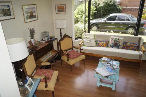 巴拉斯港Hospedaje El Roble, Puerto Varas的带沙发、椅子和汽车的客厅