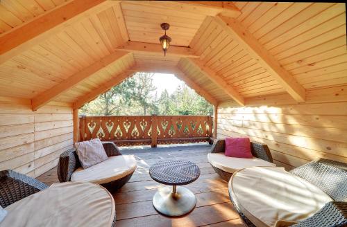 维斯瓦Sun Seasons 24 - Domek Bacówka的一个带椅子和桌子的大型木制门廊