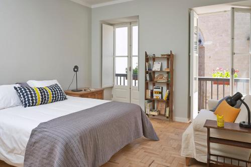 科英布拉拱形屋公寓的卧室配有白色的床和窗户。