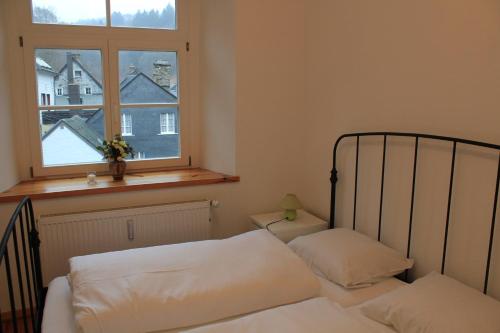蒙绍Zum alten Landrat的一间卧室设有一张床和一个窗口