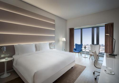 三亚三亚凤凰机场酒店的卧室配有一张白色大床和一张书桌