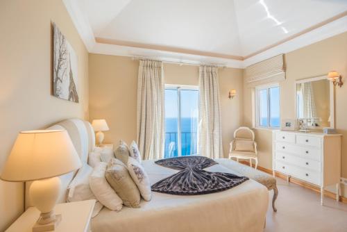 丰沙尔Luxury One Bedroom Palheiro Village by HR Madeira的一间卧室设有一张床和一个大窗户