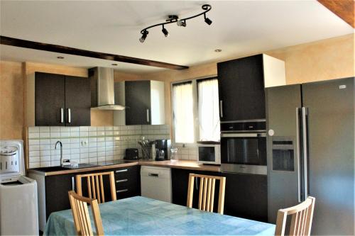 容扎克LOCATIONS RIVES DE SEUGNE - Claveau的厨房配有黑色橱柜和桌椅