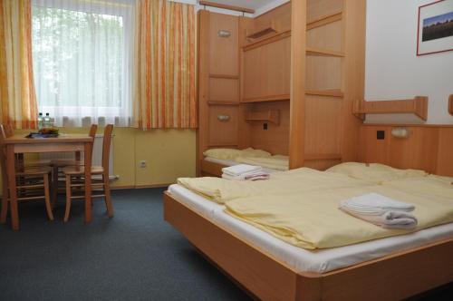 萨尔茨堡爱德华海因里希屋旅舍的一间卧室配有一张床铺和一张桌子,还有一间用餐室