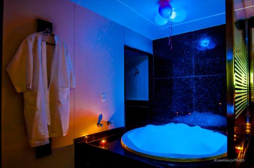 纳塔尔图卢兹汽车旅馆（仅限成人）的带淋浴的浴室(带蓝色灯光)