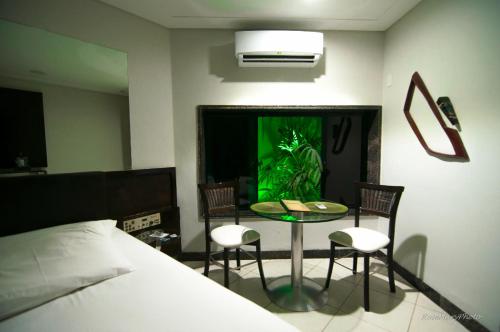 纳塔尔图卢兹汽车旅馆（仅限成人）的卧室配有一张床和一张桌子及椅子