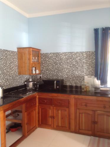 马埃岛博瓦隆公寓的厨房配有木制橱柜和黑色台面