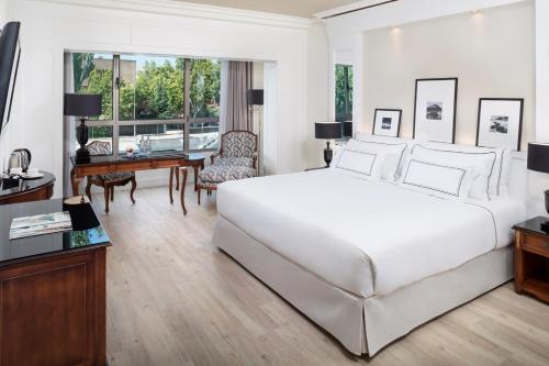 马德里巴拉哈斯美利亚酒店的卧室配有一张白色大床和一张书桌