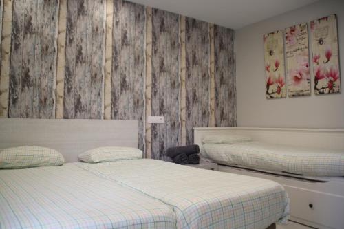 洛格罗尼奥Apartamentos Logroño Centro的一间卧室设有两张床和木墙