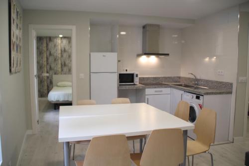 洛格罗尼奥Apartamentos Logroño Centro的白色的厨房配有白色的桌子和椅子