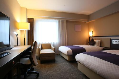 宇都宫宇都宫大和鲁酒店的酒店客房设有两张床、一张桌子和一台电视。