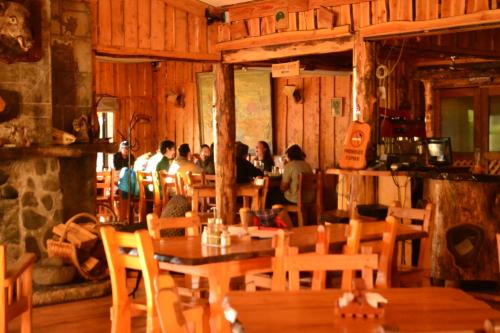 科舒恩克Hosteria-Cabañas Rucapillan的一群人坐在餐厅里,有桌椅