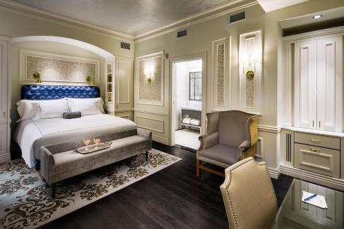 萨拉托加泉The Adelphi Hotel的一间卧室配有一张特大号床和一把椅子