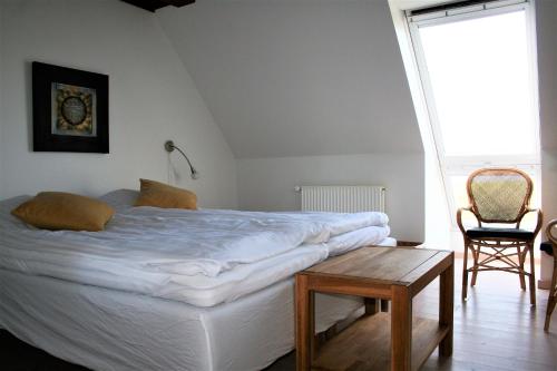凯特明讷洛德卡尔加尔德住宿加早餐旅馆的一间卧室配有一张床、一张桌子和一个窗户。