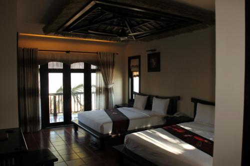 美奈莲花村度假酒店的一间卧室设有两张床和窗户。