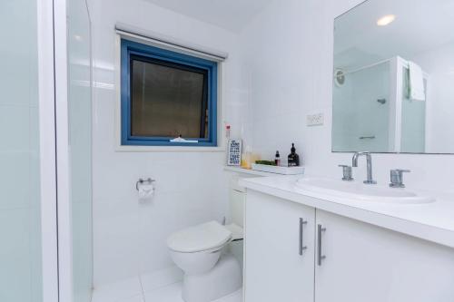 仙女港临水公寓的白色的浴室设有卫生间和窗户。