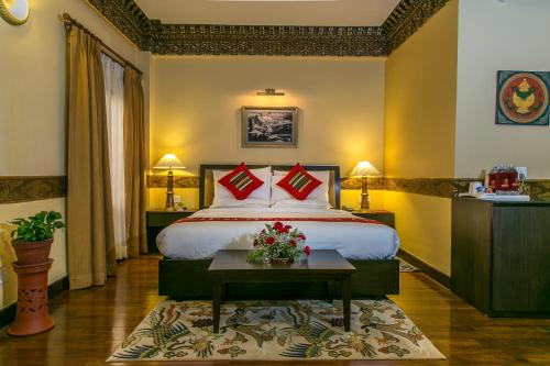 加德满都西藏国际酒店的酒店客房配有一张带红色枕头的大床