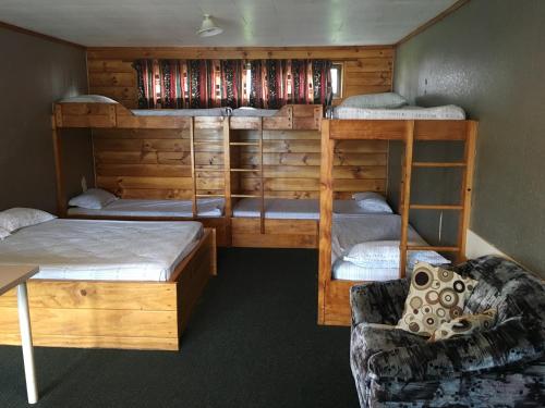 奥克兰埃文代尔汽车公园露营地的客房设有两张双层床和一张沙发。