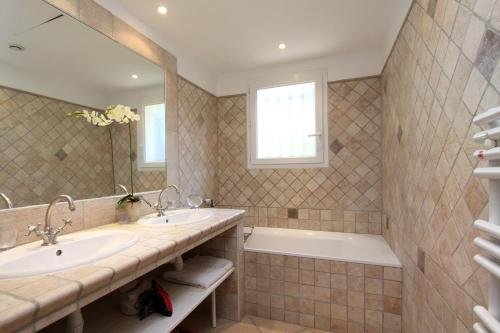 波尔蒂乔Villas les Residences de Scaglione的浴室设有2个水槽、浴缸和镜子