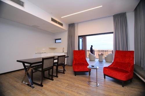 哈博罗内Room50Two的客厅配有桌子和红色椅子