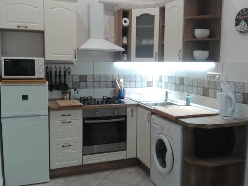 布达佩斯莉莉公寓 的厨房配有白色橱柜、水槽和洗碗机。
